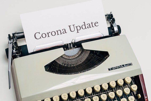 typewriter with paper that has corona update written on it