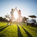 couple golfing with golf cart